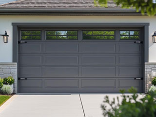 Technician installing a modern, insulated garage door on a residential home in Goodyear, AZ